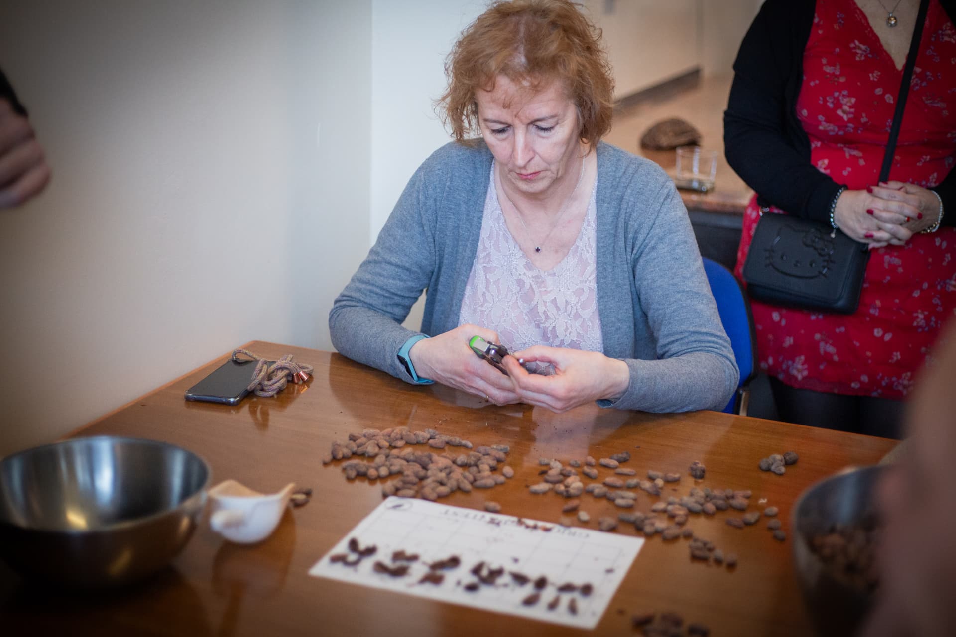 Partecipante osserva e seleziona le fave di cacao sul tavolo