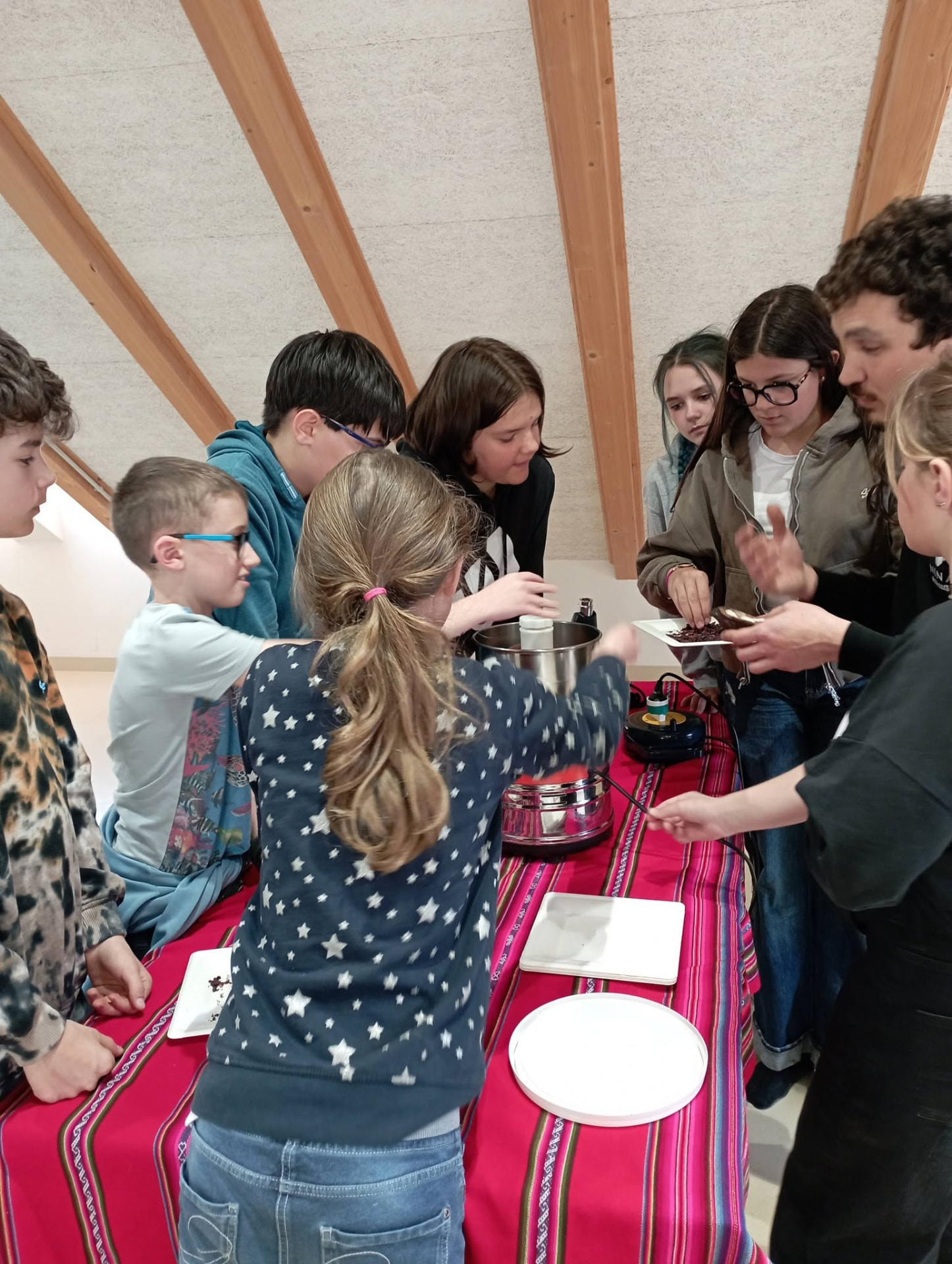 Bambini raccolti attorno alla macchina del cacao durante il laboratorio